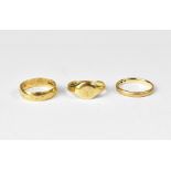 Three 9ct gold rings to include two band rings, both size K, and a small signet ring, size L,