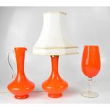 Three pieces of retro orange glassware comprising a baluster-form table lamp, height 25cm,