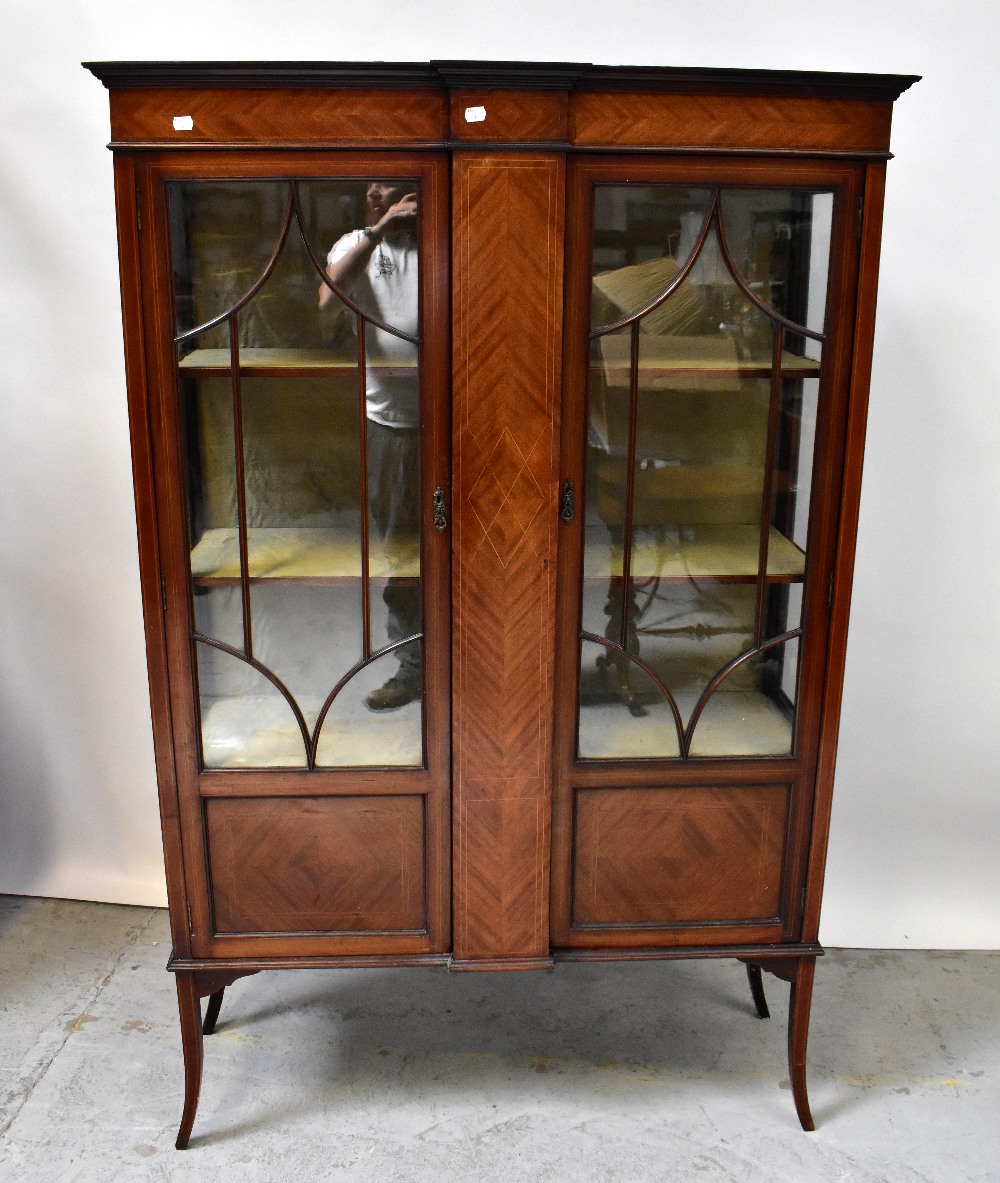 An Edwardian inlaid mahogany display cabinet with pair of astragal glazed doors flanking a central