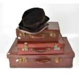 Three vintage leather suitcases of graduated sizes, two gentlemen's trilby hats,