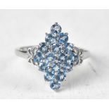 A 9ct white gold ring with a diamond-shaped cluster of sixteen London blue topaz round claw set