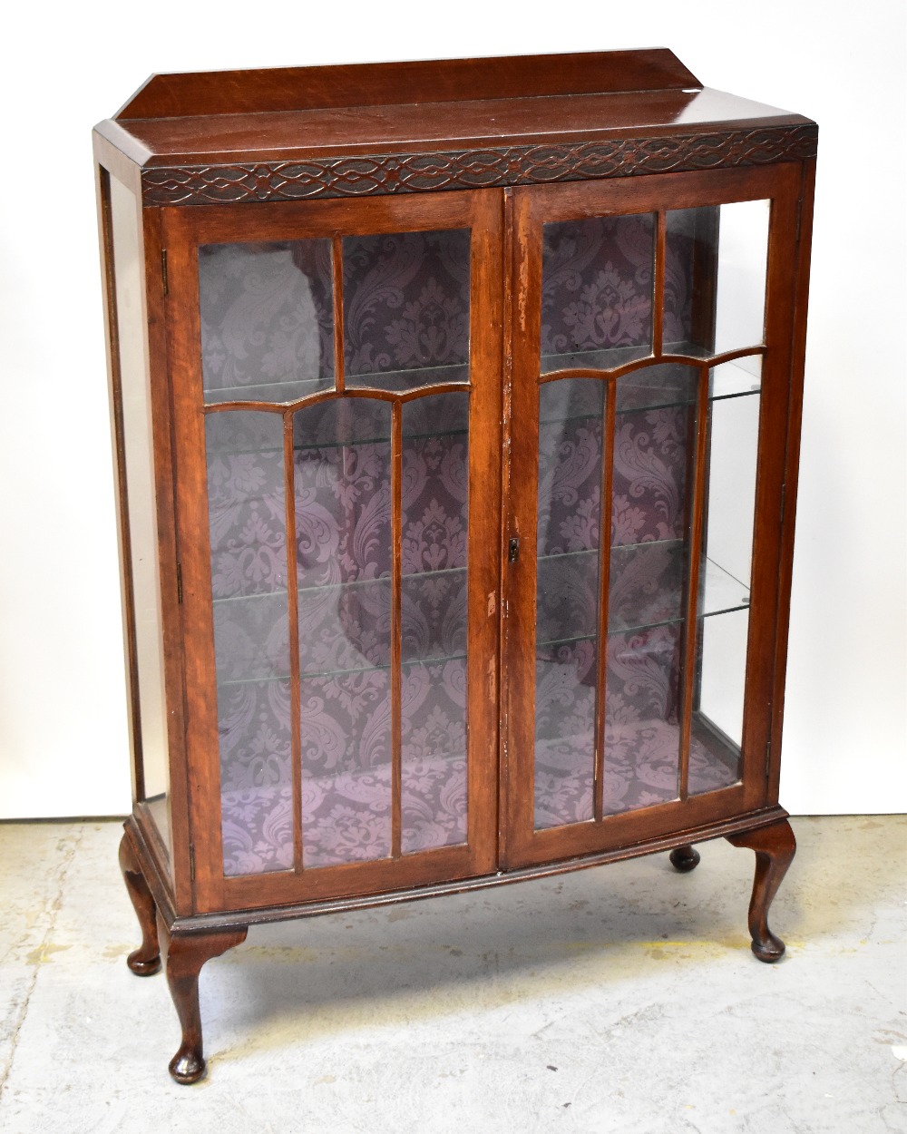 An early 20th century walnut bowfronted two-door display cabinet,