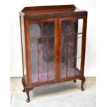 An early 20th century walnut bowfronted two-door display cabinet,