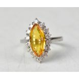 An 18ct white gold ring set with a marquise-shaped yellow tourmaline, with white diamond surround,
