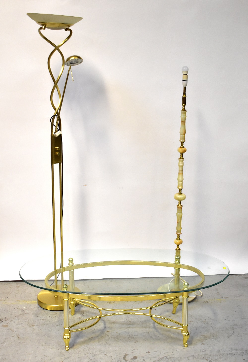 A modern oval glass-topped coffee table on brass plated Classical-style frame, 42 x 124 x 63cm,