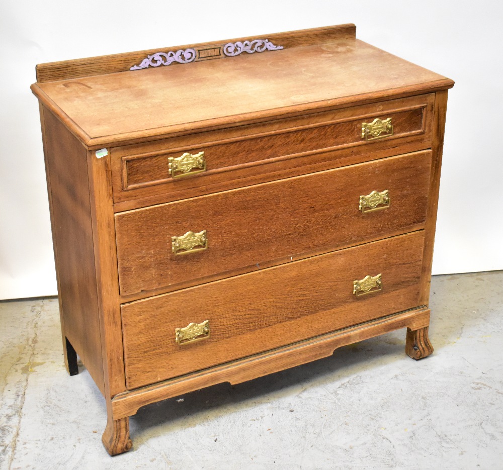 An early 20th century oak chest of three graduated drawers, each with brass drop handles,