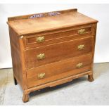 An early 20th century oak chest of three graduated drawers, each with brass drop handles,