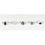 Five sterling silver rings, each with a different gemstone,