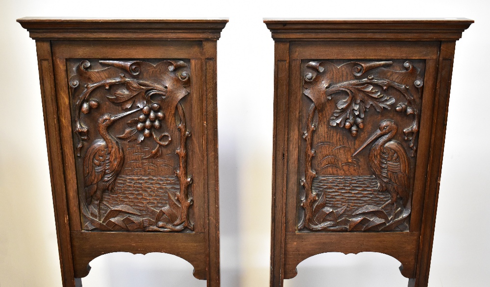 A pair of late Victorian carved oak hall chairs, each panelled back decorated with a stork, - Bild 2 aus 2