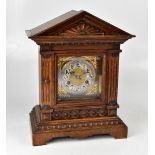 JUNGHANS; a c1900 oak architectural cased mantel clock, the silvered dial set with Arabic numerals,