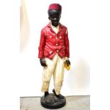 A large resin figure of a young gentleman wearing a fez and red jacket,