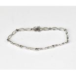 A 9ct white gold bracelet with figure of eight links separated by tiny bezel set diamonds,