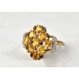 A 9ct yellow gold ring set with a cluster of Madeira citrine and Mozambique garnet stones, size U,