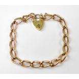 A 9ct rose gold bracelet with elongated oval links united with a 9ct yellow gold padlock clasp and