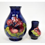 MOORCROFT; two Walter Moorcroft vases, both with tube-lined 'Clematis' pattern on blue ground,
