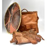 A group of tribal items including a painted hide shield, rustic wooden bowl, mask, etc.