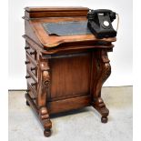 A reproduction mahogany Davenport with four drawers opposing four faux drawers,