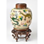 A ginger jar decorated with green, yellow, blue and red dragons, on a cream crackle glaze ground,