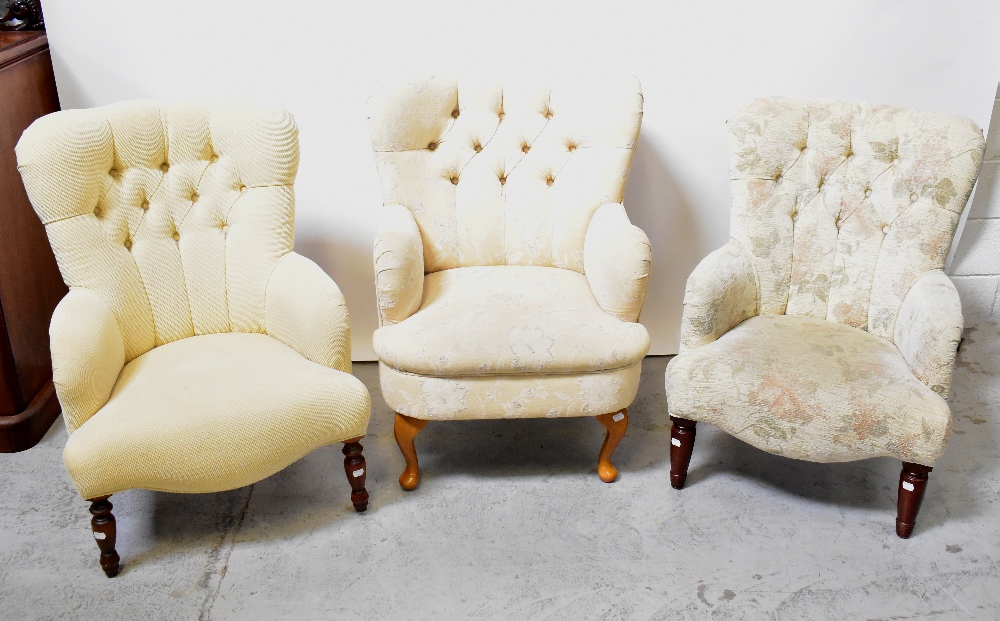 Three Victorian-style button back tub armchairs, each upholstered in a cream fabric,