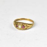 A 19th century style 9ct yellow gold ring set with small white opal flanked by two tiny rubies in