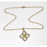 A 9ct gold Edwardian-style necklace pendant with centred bezel set peridot flanked by four seed