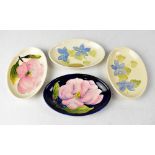 MOORCROFT; four oval pin dishes, two with periwinkle decoration and two with magnolia decoration,