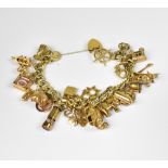 A 9ct gold charm bracelet with approximately twenty-four gold charms, to include Indian elephant,