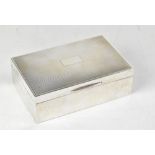 A George V hallmarked silver cigarette box with engine turned lid and blank rectangular cartouche,