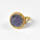 A yellow gold ring with bezel set protruding amethyst carved with flower design,