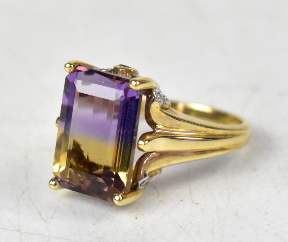 A 9ct yellow gold ring with an emerald cut ametrine bi-colur stone, on an ornate mount, size N,