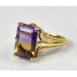 A 9ct yellow gold ring with an emerald cut ametrine bi-colur stone, on an ornate mount, size N,
