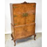 A reproduction walnut veneered cocktail cabinet,
