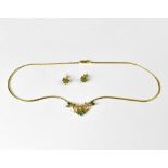 A modern 14ct yellow gold Italian necklace with seven small oval cut emeralds and five small