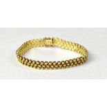 An Italian 9ct gold bracelet comprising three rows of gold beads, mounted on articulated links,
