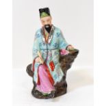 An early 20th century Japanese figure depicting a teacher/scribe, wearing patterned clothes,