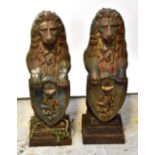 A pair of metal garden statues in the form of lions raised on their back legs,