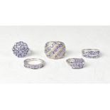 Five sterling silver and tanzanite set rings, comprising a floral cluster ring, size P,