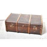 An early 20th century wooden bound canvas covered travelling trunk with metal fittings,