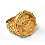 A George V 1912 full sovereign mounted in a 9ct gold ring with floral pierced shoulders, size X,