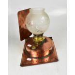 A copper oil lamp on rectangular stand a