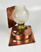 A copper oil lamp on rectangular stand a
