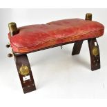 A red leather upholstered camel saddle w