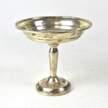 A white metal bowl with slender stem to