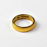 A yellow metal wedding band, marked to i