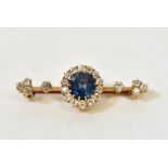 A sapphire and diamond bar brooch with central claw set sapphire, diameter approx 0.