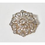 A possibly late 19th century yellow metal diamond cluster brooch with a central bezel set brilliant