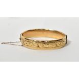 A 9ct yellow gold hinged bangle, with in