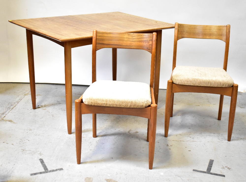 A 1970s vintage extending dining table on four turned tapered supports,