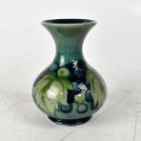 WILLIAM MOORCROFT; a 'Leaves and Fruit' patterned short vase with flared neck,