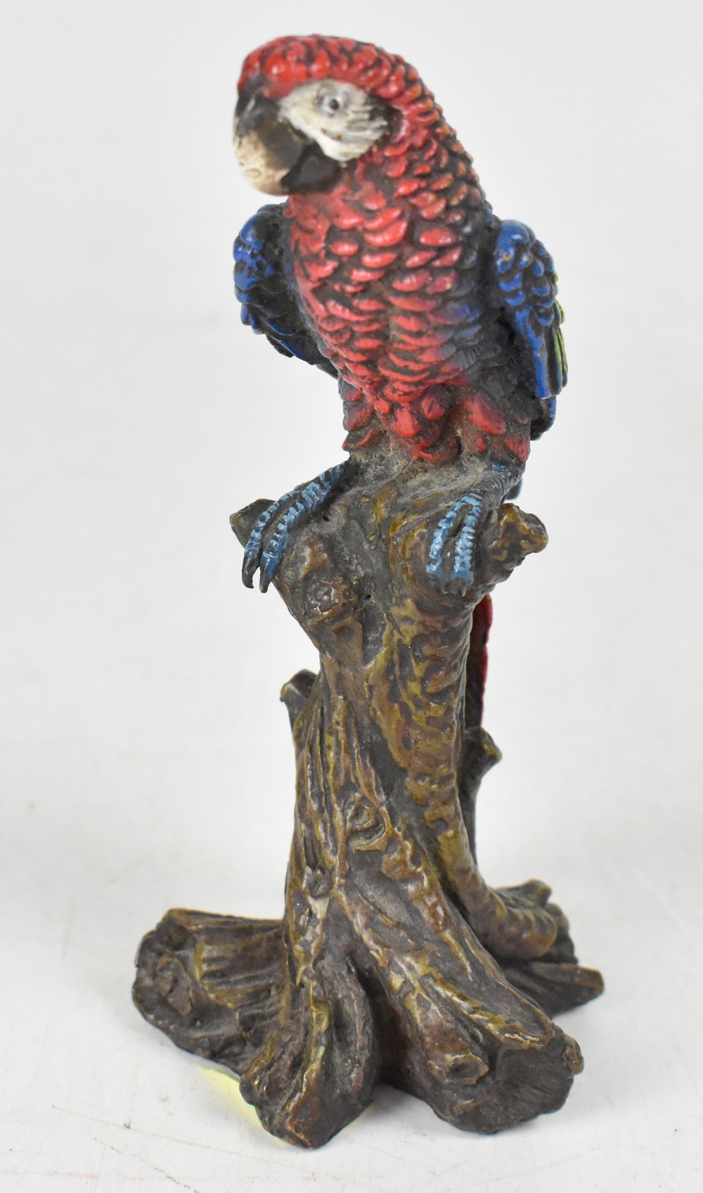 A small 19th century cold painted bronze figure depicting a colourful parrot perched on a branch,